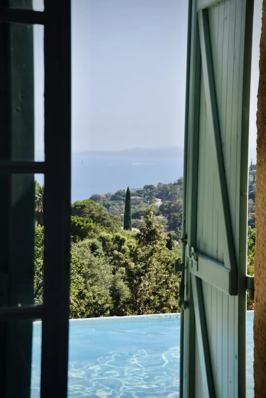 Vista de una piscina a través de una contraventana